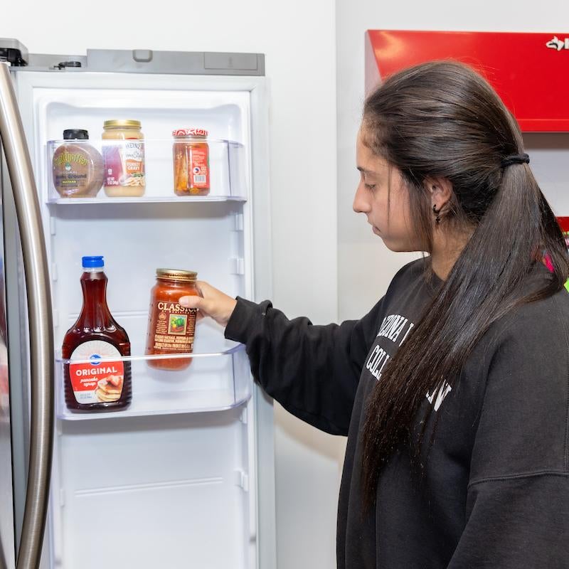 Student getting food from the refrigerator at The Cubby