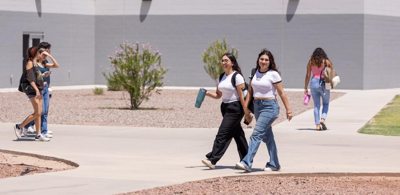 Two female students walking on Yuma campus